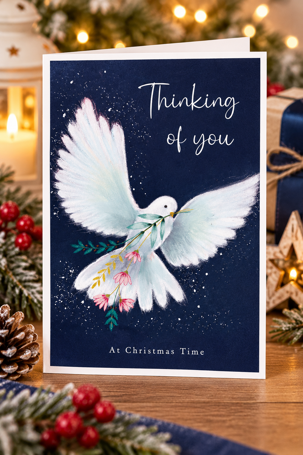 White dove Thinking of You Christmas card displayed with festive candles and decorations