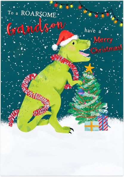 Otter House Grandson Christmas card front with green dinosaur in Santa hat decorating tree and To a Roarsome Grandson message