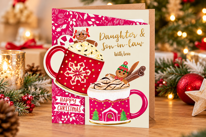 Daughter and Son-in-law Christmas card displayed on festive table with candle, Christmas lights and seasonal greenery
