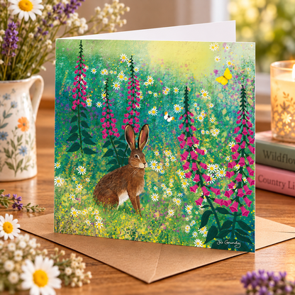 Jo Grundy hare meadow greeting card displayed on a table in a cosy lifestyle scene