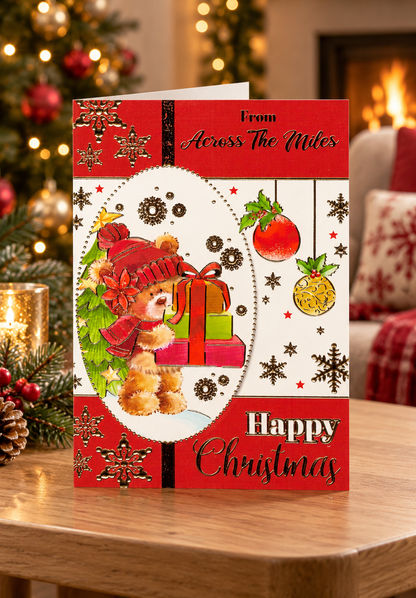 Across the Miles teddy bear Christmas card displayed in a cosy living room