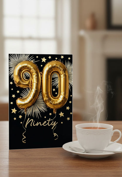 Made To Be Treasured Abacus 90th birthday card with gold foil balloon numbers on a black background with starbursts.