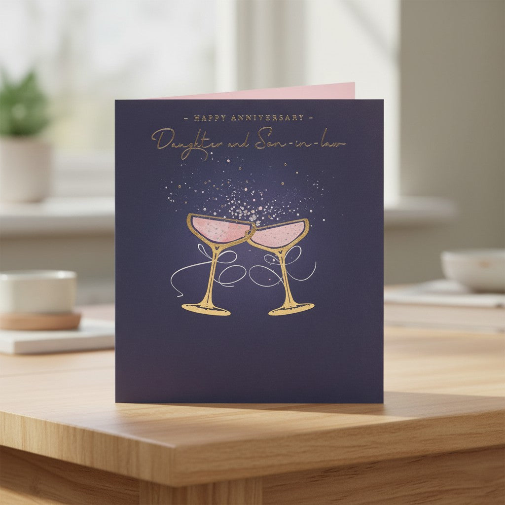 Made To Be Treasured navy anniversary card for daughter and son-in-law with gold foil champagne glasses and bubbles.