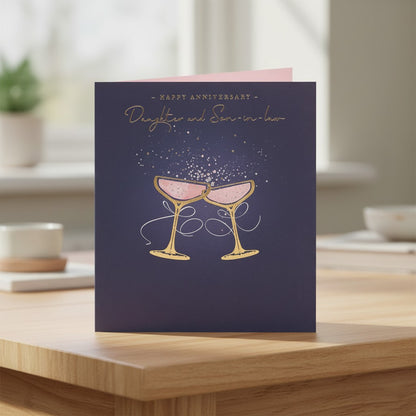 Made To Be Treasured navy anniversary card for daughter and son-in-law with gold foil champagne glasses and bubbles.