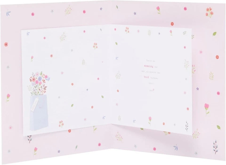 Made To Be Treasured Boofle birthday card for mum, featuring a floral bouquet in a blue bag and gold foil details. Pink floral pattern.