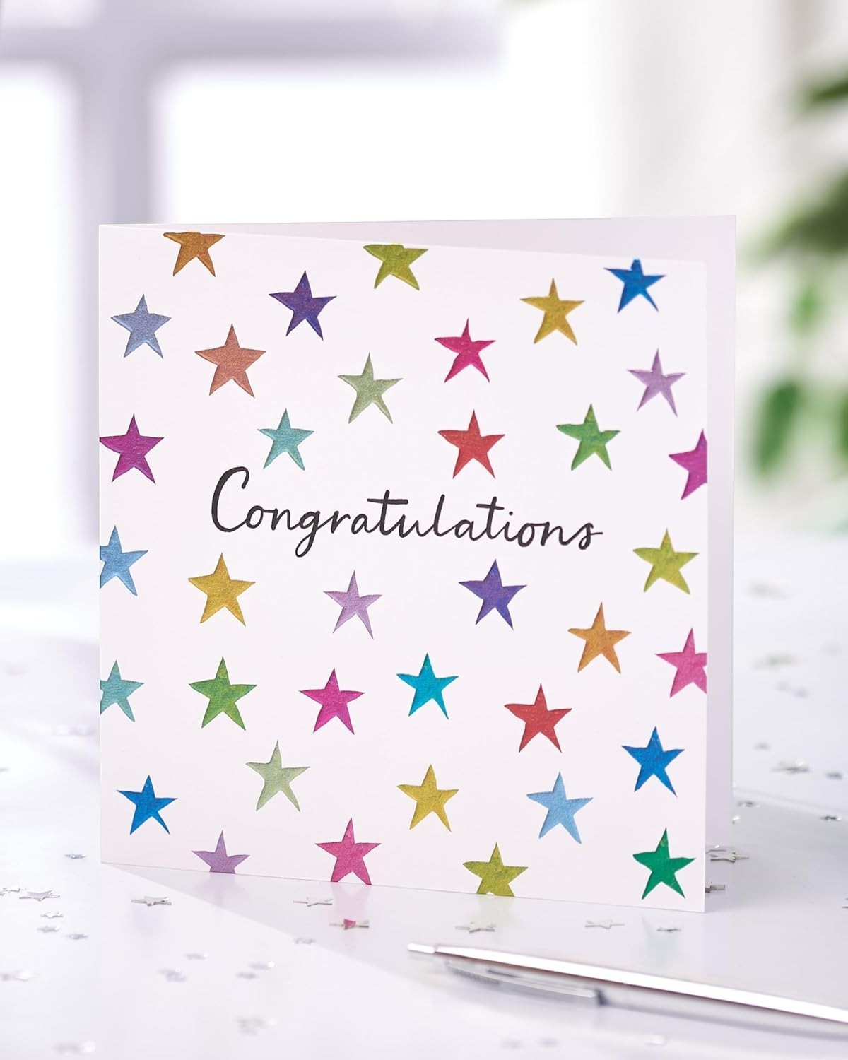 Made To Be Treasured congratulations card with colourful stars design and text 'Congratulations' on the front.