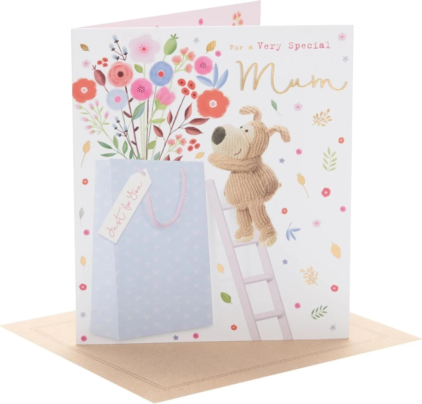 Made To Be Treasured birthday card for Mum featuring a knitted dog on a ladder reaching for a gift bag, with floral accents and gold foil text.