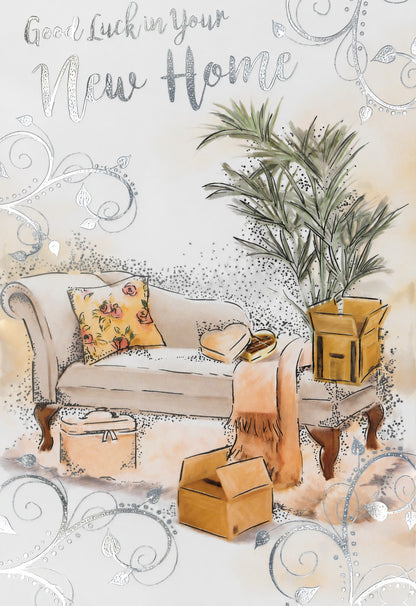 Made To Be Treasured Good Luck In Your New Home card with silver foil text, sofa, plant, and moving boxes.