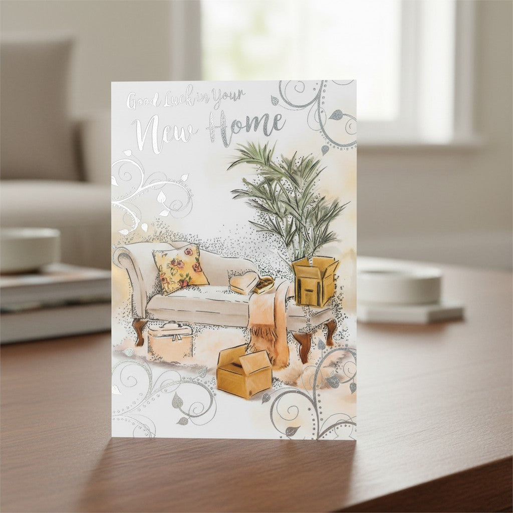 Made To Be Treasured Good Luck In Your New Home card with silver foil, featuring a sofa, plant, and moving boxes.